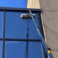 Lavaggio delle vetrate di una facciata con asta ad acqua