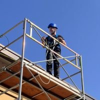 Operatore su ponteggio con casco e imbragatura